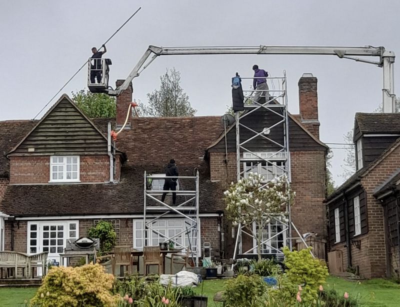 The Moss Cleaners using cherry picker and scaffolding to clean roof safely and professionally in Chippenham, Wiltshire
